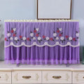 Stylish mix-color dustproof TV cover draped over a television in a home setting.