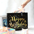 Close-up of golden star design on black reusable birthday gift bag
