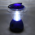 The blue and clear plastic lantern is brightly illuminated, casting a glow on the surrounding gray surface.