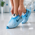 Person wearing blue disposable plastic shoe covers indoors.