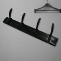 Top-down view of the 4-hook wall mount coat hanger holding various coats and hats.