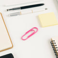 Assorted colourful vinyl-coated paper clips neatly arranged on a clean white background.