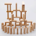 A player carefully removing a wooden block from the mid-section of the tall tumbling tower.