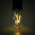 A close-up of the clear bulb of a portable LED tent light shows the glowing orange filament against a dark background.