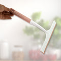 A hand demonstrating the small detailing brush for intricate cleaning tasks.
