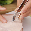 Fish bone tweezer placed on kitchen countertop showing ergonomic handle
