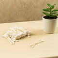Side view of soft, tightly wound cotton tips on paper sticks.