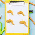 Side view of the chicken erasers, showing their three-dimensional form and playful appearance.