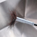 Spring drain cleaner removing hair clog from sink pipe