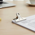Close-up of strong metal spring paper clamp clip in action
