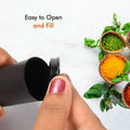Two sleek spice dispensers enhancing a contemporary dining table setting.
