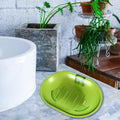 White plastic soap dish holding a bar of soap in a clean bathroom.