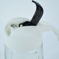 Pouring olive oil using glass oil bottle dispenser in kitchen setting