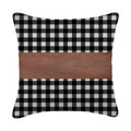 A set of contemporary leather pillow covers arranged on a comfortable armchair.