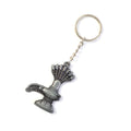 Hand holding Shiva Lingam metal keychain with spiritual Naag motif