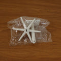 Versatile adhesive hook applied to a glass surface, holding various small items.