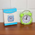 Portable compact quartz analog alarm clock in green transparent frame