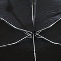 The interior of a black umbrella reveals its silver metal spokes and central mechanism.