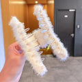 Plush hair claw clip securing a full head of hair, showing its strong yet gentle grip.