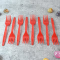 Stacked red disposable forks showing compact, portable design