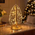 Festive decoration featuring golden crystal leaf LED table lamp on wooden surface
