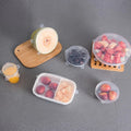 Clear silicone stretch lids covering plates with leftovers.