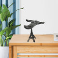 Side view of the Balancing Eagle Toy gracefully perched on its Eiffel Tower stand, demonstrating its perfect balance.