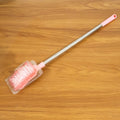 Toilet brush in use cleaning toilet bowl with long handle and splash-resistant head
