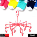 Compact plastic clothes hanger with clips in a folded position, showing portability.