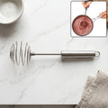 Steel whisk for eggs and cream mixing in kitchen