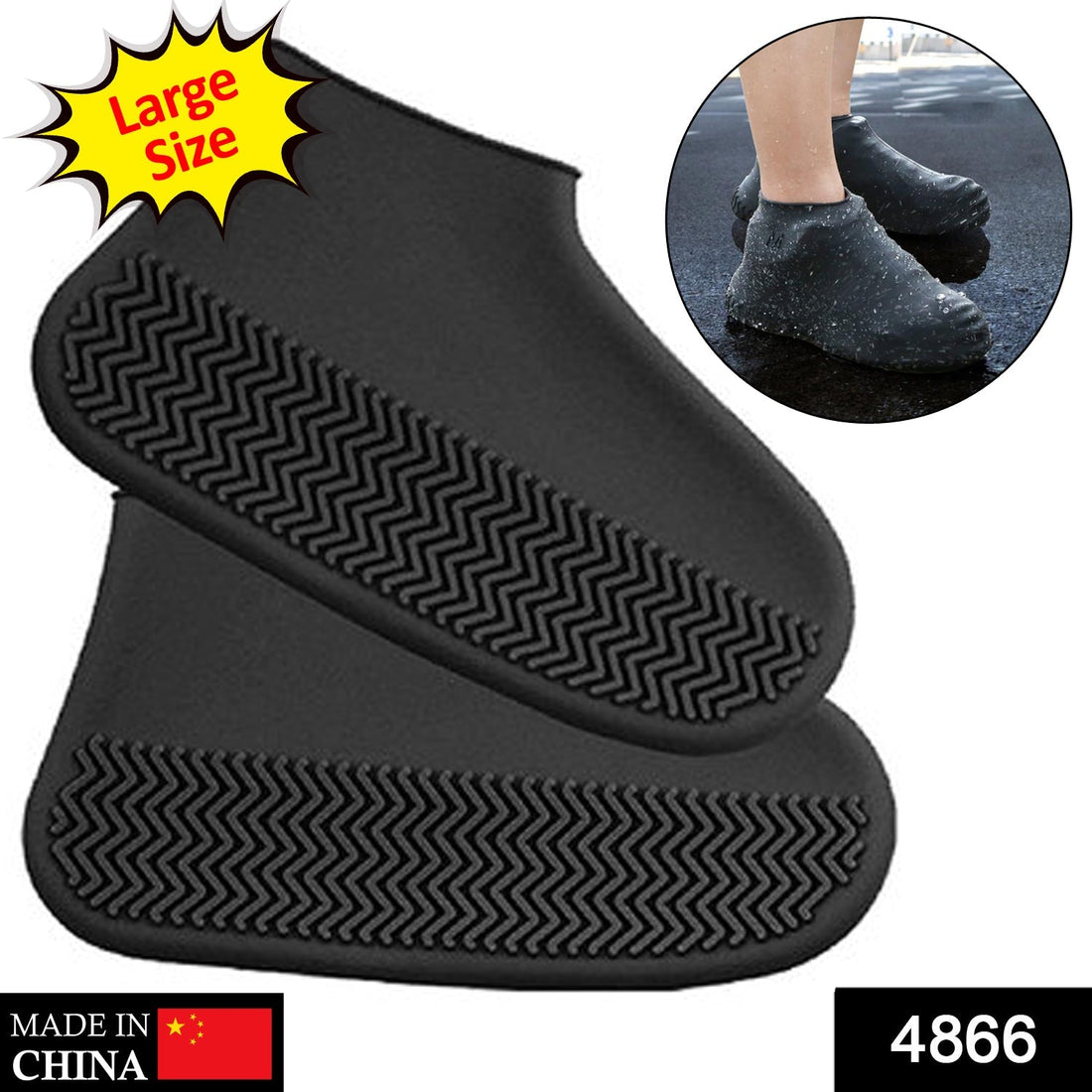 A person's feet wearing black silicone shoe covers stand on a wet, textured metal surface with green plants.