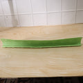 Side angle view of the flexible kitchen sink splash guard on a wooden counter.