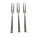 Three small appetizer forks laid out for serving snacks