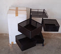 An assembled metal kitchen trolley with wheels, neatly holding various kitchen accessories.