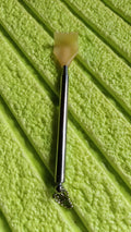 The compact back scratcher displayed neatly in its product packaging.