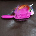 Young girl gently brushing her hair with the Kids Unicorn Detangling Brush