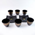 Stack of ceramic bowls and cups from the 8-piece collection by Indo Glow.