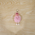 Plush doll keychain hanging on bag strap showing soft fur ball charm