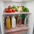 Transparent fridge mats protecting multiple refrigerator shelves from food stains