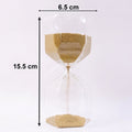 Smooth yellow sand flowing inside an elegant glass hourglass timer.