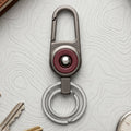 Durable metal key holder with dual rings and locking clip attached to a backpack