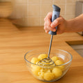 Close view of stainless steel potato masher spring and handle