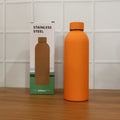 Lifestyle image featuring stainless steel insulated orange water bottle