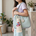 Glass water bottle showcasing cherry motif and flower charm, perfect for on-the-go