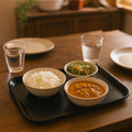 Stacked black plastic serving trays demonstrating space-saving design