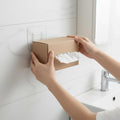 Transparent adhesive wall hook securely mounted in a modern bathroom setting.
