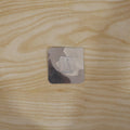 Self adhesive wall hook securely holding items in a home setting.
