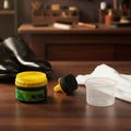 Applying black shoe polish cream with built-in sponge on leather shoe