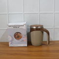 A person holding the self-stirring coffee mug, demonstrating its comfortable grip and portability.