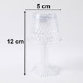 Small crystal table lamp creating a warm, ambient glow in a dark room.